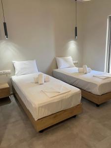 two beds sitting next to each other in a room at Mangata Seaside Hotel in Rovies