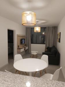 sala de estar con mesa blanca y sillas en Departamento 1 Dormitorio Torre Quarz 902 en Neuquén
