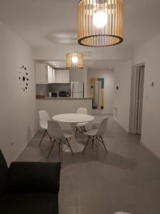 comedor y cocina con mesa y sillas en Departamento 1 Dormitorio Torre Quarz 902 en Neuquén