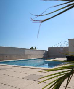 a swimming pool in front of a building at Apartman Boem in Trogir