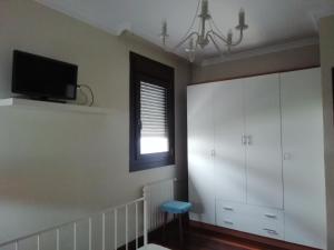 a living room with a tv and a window at Casa Airiños do monte in Cangas de Morrazo