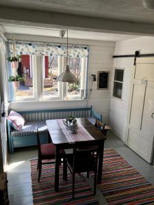 uma sala de jantar com uma mesa e cadeiras e um sofá em Savikulma savihuone B&B em Mynämäki