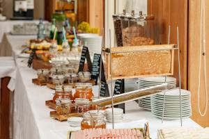 a buffet line with plates and jars of honey at Hotel Dom Goncalo & Spa in Fátima