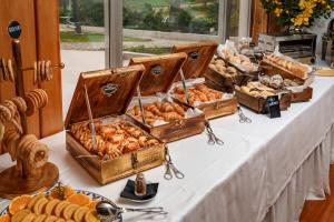 a table topped with baskets of bread and pastries at Hotel Dom Goncalo & Spa in Fátima