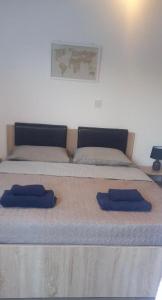 a bed with two blue pillows on top of it at Valentinas apartment ! in Polis Chrysochous +11 photos