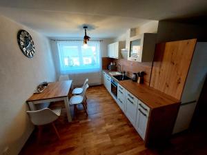 a kitchen with a wooden table and a table and chairs at Panoramatický apartmán Tatry in Nová Lesná