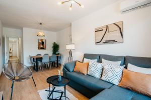 salon z niebieską kanapą i stołem w obiekcie tuGuest Halcón Apartment w Grenadzie
