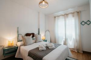 sypialnia z łóżkiem i ręcznikami w obiekcie tuGuest Halcón Apartment w Grenadzie