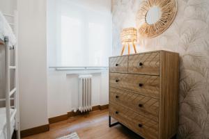 sypialnia z komodą i lustrem na ścianie w obiekcie tuGuest Halcón Apartment w Grenadzie