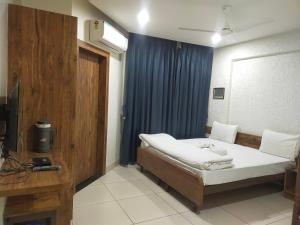 a bedroom with a bed and a blue curtain at Hotel Kartiki in Aurangabad
