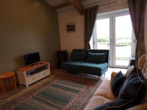 a living room with a couch and a tv at Detached barn with valley views near Cardigan in Cardigan