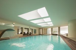 a swimming pool with a water fountain in a building at Hotel Dom Goncalo & Spa in Fátima