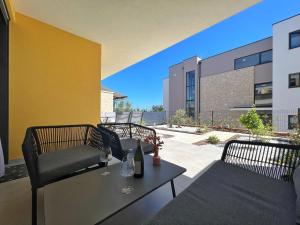 a patio with two chairs and a table with wine glasses at Apartment Corsy in Novigrad Istria