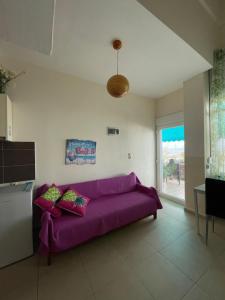 a purple couch in a living room with a window at Maria Studio in Nea Karvali