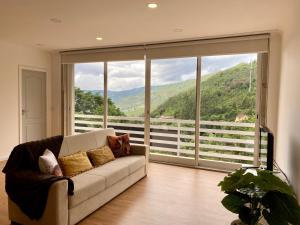 a living room with a couch in front of a large window at Gerês Distinto in Geres