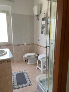 a bathroom with a toilet and a sink and a shower at The Orange House in Assemini