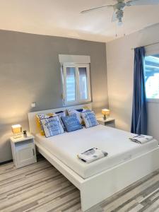 a bedroom with a large white bed with blue pillows at Apartments Stara Baska in Stara Baška