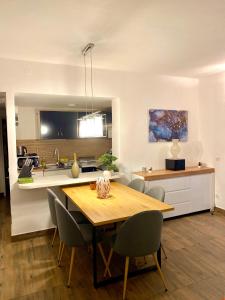 a kitchen and dining room with a wooden table and chairs at Apartments Stara Baska in Stara Baška