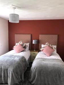 two beds sitting next to each other in a bedroom at Welsh Getaway Home No 1 - 10 mins to Bike Park Wales in Merthyr Tydfil