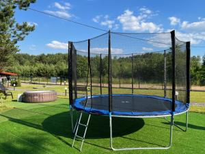 a trampoline with a net on a green field at Ośrodek u Antosia na Mazurach in Narty