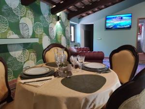 une table avec des assiettes et des verres dans une pièce dans l'établissement Villa La Nussa, à Capolona
