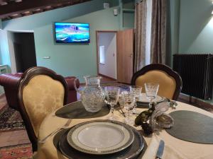 - une table à manger avec des verres et des assiettes dans l'établissement Villa La Nussa, à Capolona