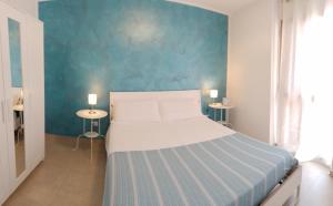 a bedroom with a large bed with a blue wall at La casetta di Clary in Polignano a Mare