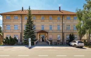 a large building with a car parked in front of it at Apartments and Rooms kod Eli in Ravna Gora