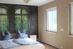 a bedroom with two beds and two windows at Landperle Darze in Altenhof