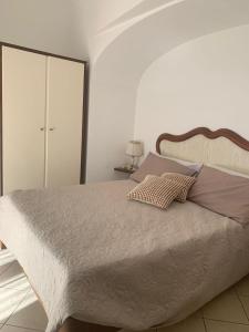 biała sypialnia z dużym łóżkiem i szafą w obiekcie Casetta Eva w mieście Anacapri