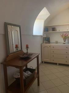 een badkamer met een wastafel en een spiegel op een tafel bij Casetta Eva in Anacapri