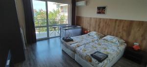 a bedroom with a bed and a large window at Къща, стаи за гости Мери in Chernomorets