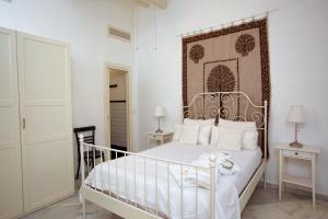 1 Schlafzimmer mit einem weißen Bett und einem verzierten Kopfteil in der Unterkunft Barroso 4 by 7Escalones in Rota