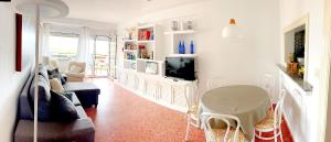 uma sala de estar com um sofá e uma televisão em Apartamento Roquetas de Mar Urbanización, 2 dormitorios, Gran Terraza con vista al mar, wi-fi, parking y piscina em Roquetas de Mar