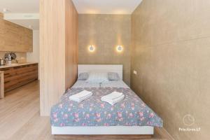 a bedroom with a bed with two towels on it at HAPPY SUMMER HOLIDAYS in Juodkrantė