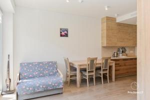 a dining room with a table and a chair at HAPPY SUMMER HOLIDAYS in Juodkrantė