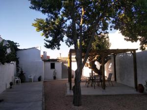 un patio con una mesa y un árbol en Casa Fraile, en Olmedilla del Campo