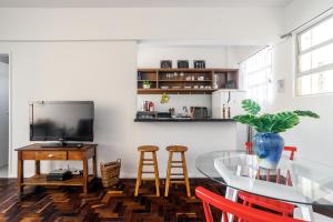 a dining room with a table and a tv at Comodidade no Coração de Floripa in Florianópolis