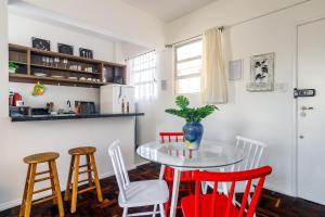 una cocina con una mesa con sillas rojas y una barra en Comodidade no Coração de Floripa en Florianópolis
