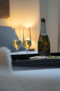 two glasses of wine next to a bottle of wine at New Dimora Valmar in Polignano a Mare