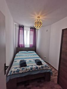 a bedroom with a bed in a room with a chandelier at Apartmani Viktorija in Fažana