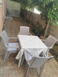 a white table and chairs on a patio at Apartmani Viktorija in Fažana