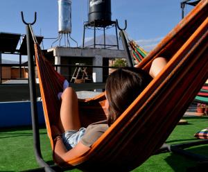 a child laying in a hammock on a playground at Econunay Hostels in Arequipa