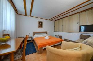a room with a bed and a table and a couch at Olive Garden Apartments in Sveti Stefan
