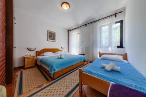 1 dormitorio con 2 camas y ventana en Olive Garden Apartments, en Sveti Stefan