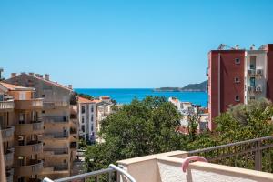 a view of the city from the balcony of a building at Olive Garden Apartments in Sveti Stefan +15 photos