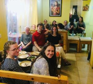 un grupo de personas sentadas alrededor de una mesa en MONALISA HOSTEL, en Varanasi