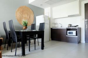 a black dining room table with black chairs in a kitchen at E303 Baan Sanpluem Hua Hin By Pat in Hua Hin