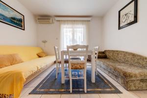 sala de estar con sofá, mesa y sillas en Olive Garden Apartments, en Sveti Stefan