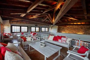 a living room with white furniture and red pillows at Due Lune Puntaldia Resort & Golf in San Teodoro
